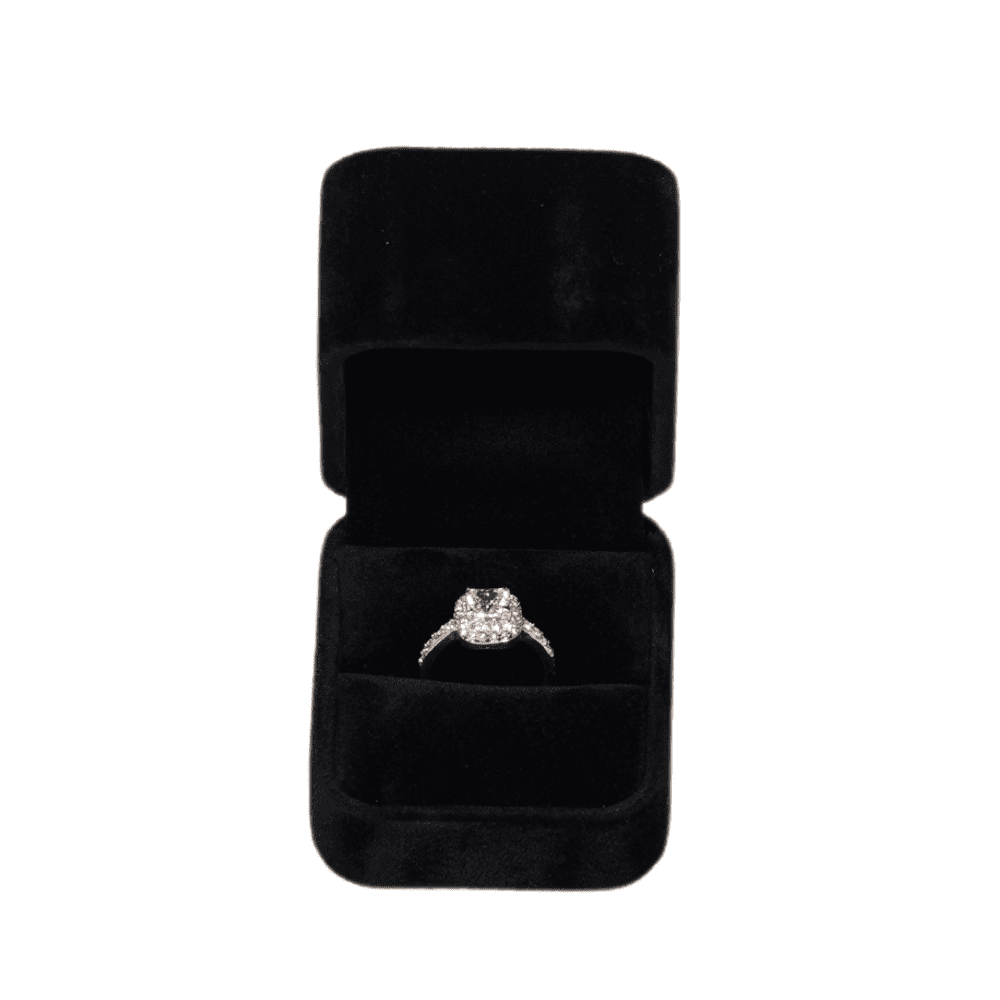 Black velvet ring box with a cushion interior, displaying an engagement ring top