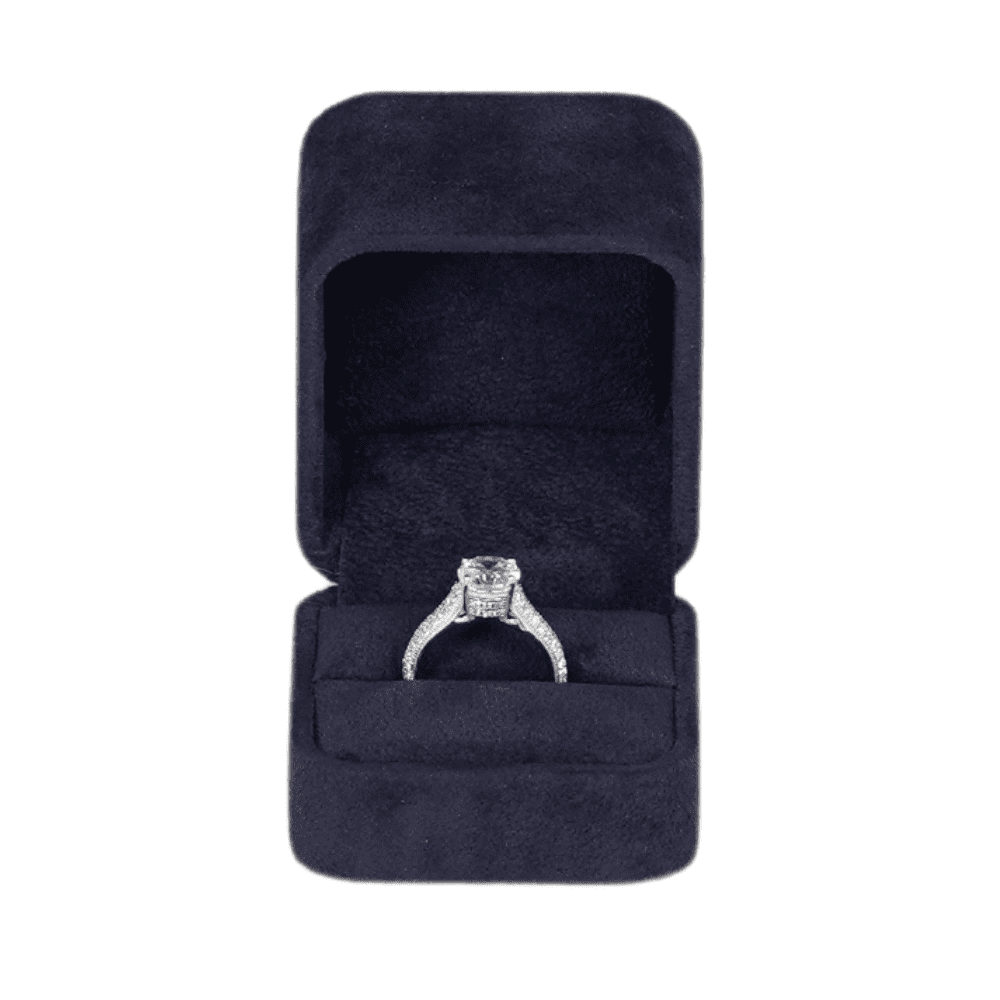 Royal blue velvet ring box with a cushion interior, displaying an engagement ring front