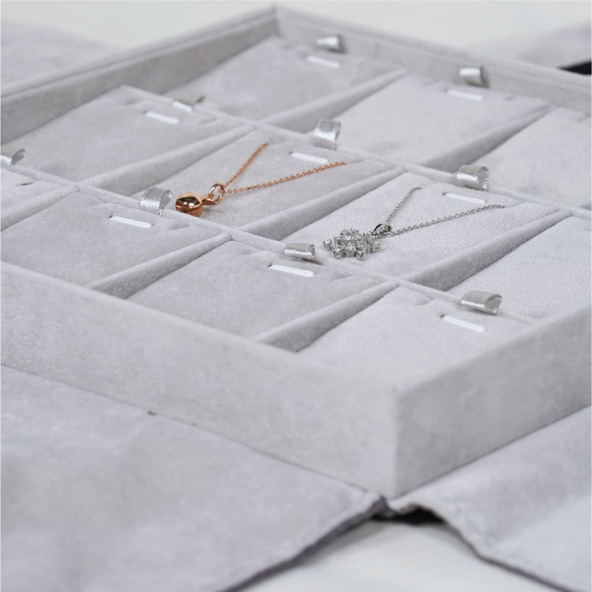 Multi-Compartment Jewellery Tray for Necklaces and Pendants-grey-TRP81-2 Close-up of a grey velvet jewellery tray with organized compartments displaying necklaces.